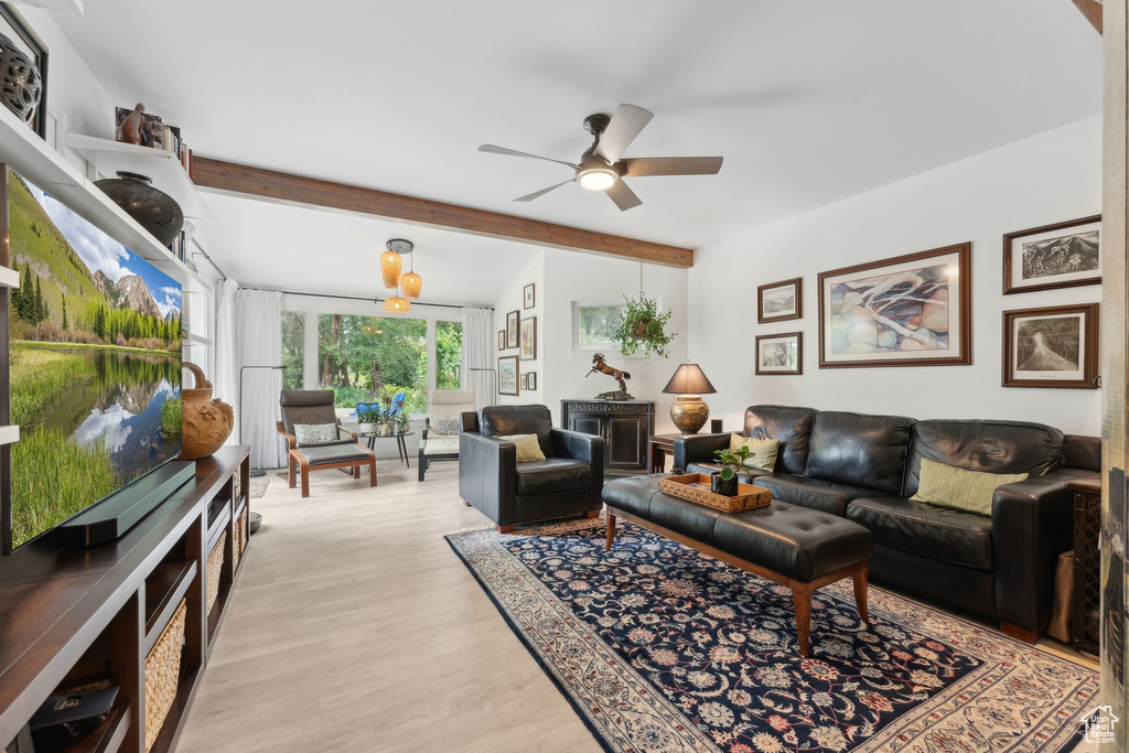 Living room with ceiling fan, beamed ceiling, and light wood-style floors