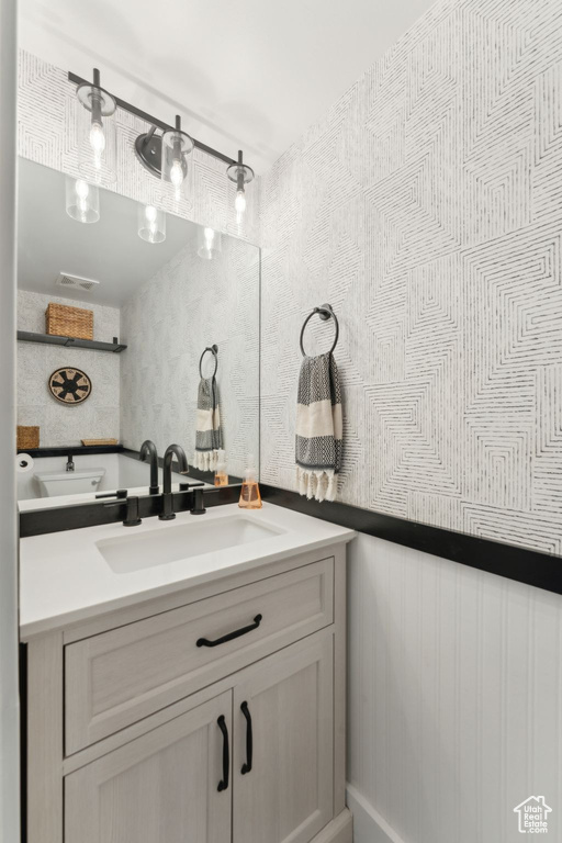 Bathroom with vanity and wallpapered walls