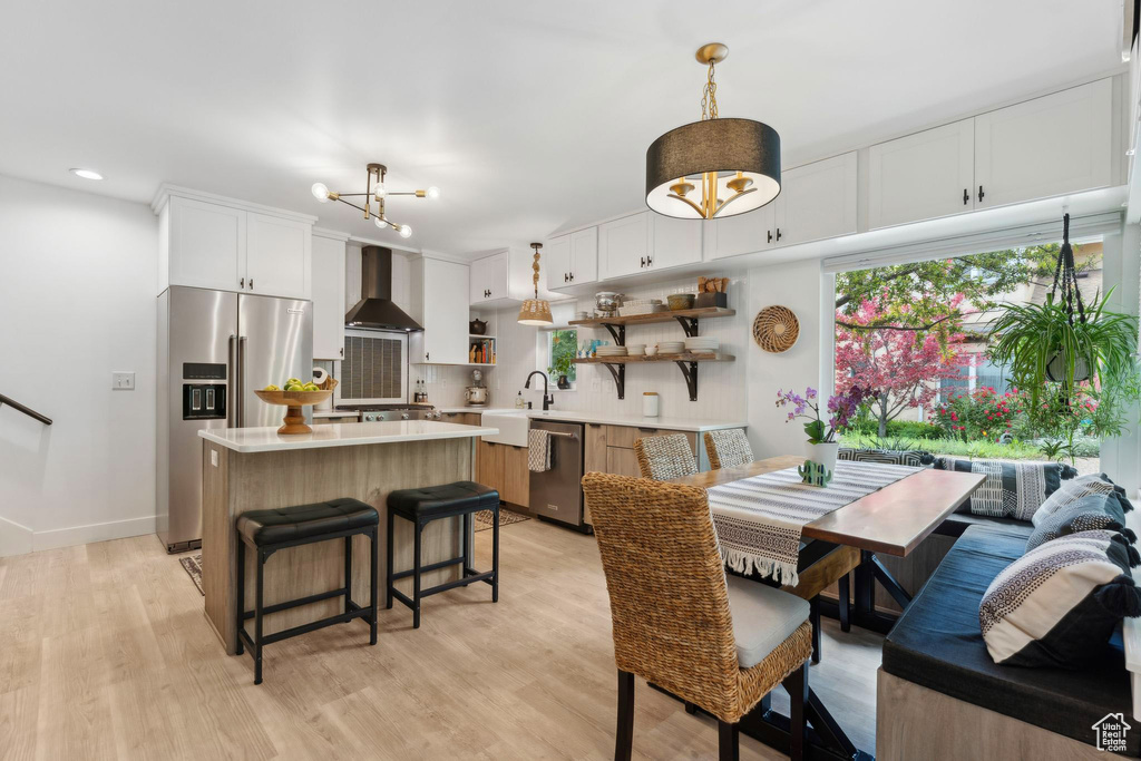 Dining space featuring light wood finished floors, a chandelier, recessed lighting, and baseboards
