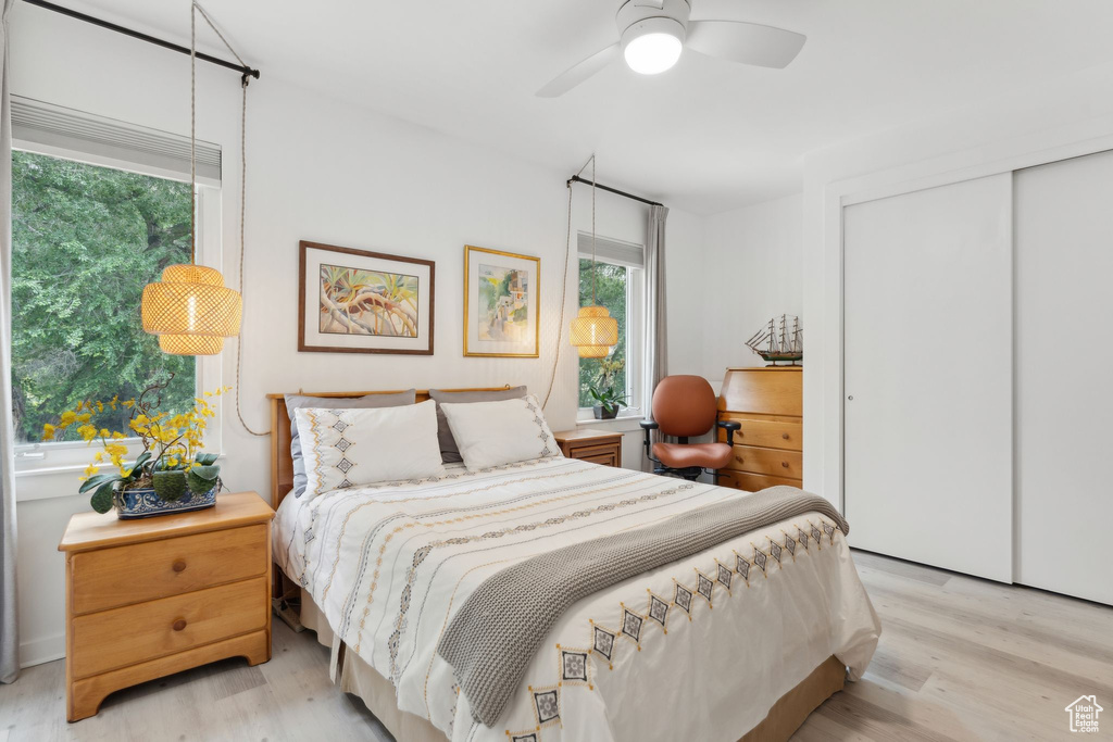 Bedroom featuring light wood finished floors, a closet, and a ceiling fan