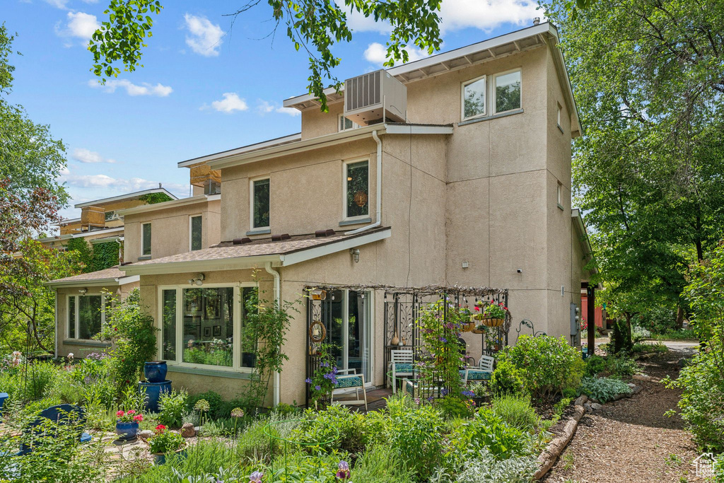 Back of house with stucco siding and cooling unit
