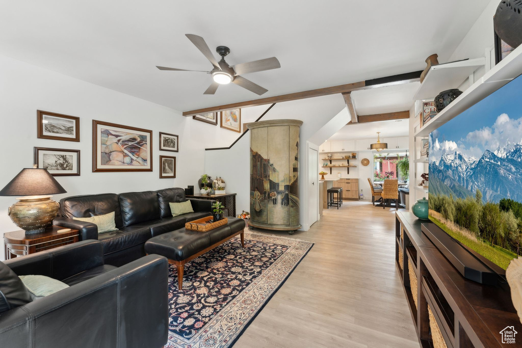 Living area with a ceiling fan and light wood-style flooring
