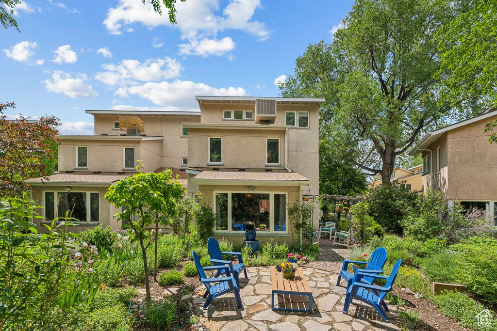 Rear view of house with stucco siding and a patio area