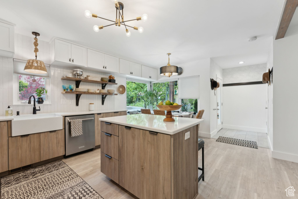 Kitchen with dishwasher, a sink, open shelves, light wood-style floors, and light countertops