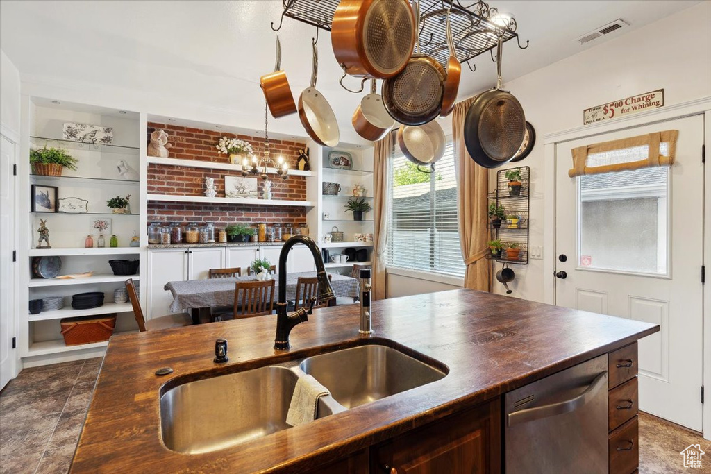 Kitchen featuring dishwasher, a sink, and wooden counters