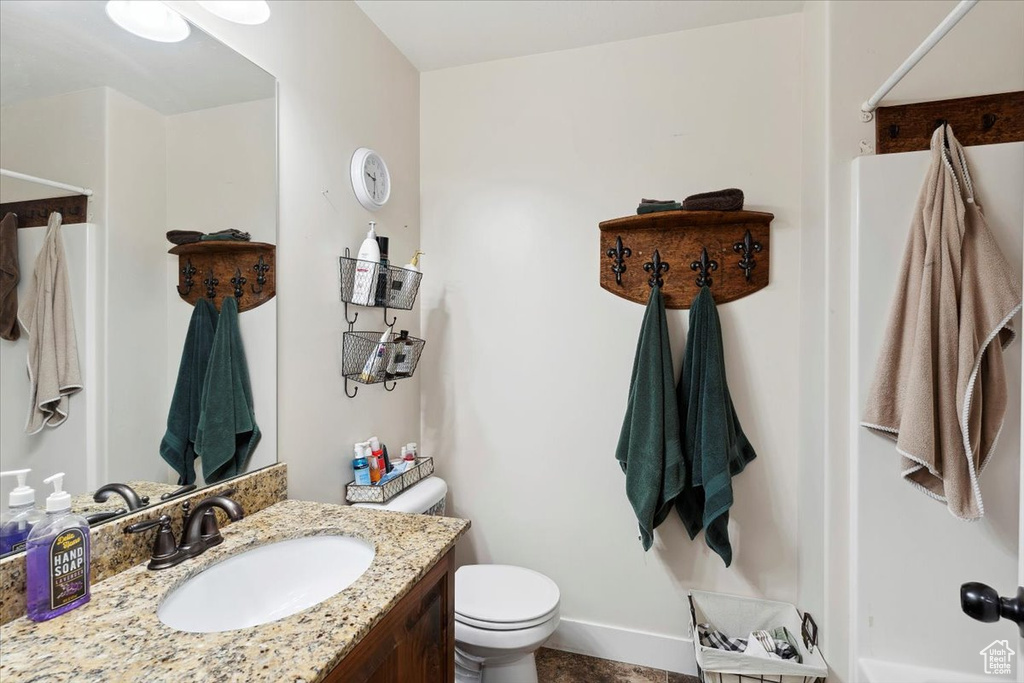 Full bath featuring toilet, a shower, and vanity