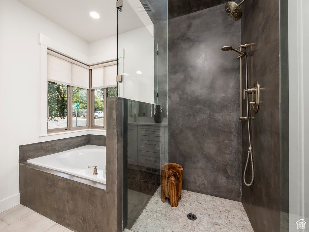Bathroom featuring a walk in shower, a garden tub, recessed lighting, and tile patterned flooring