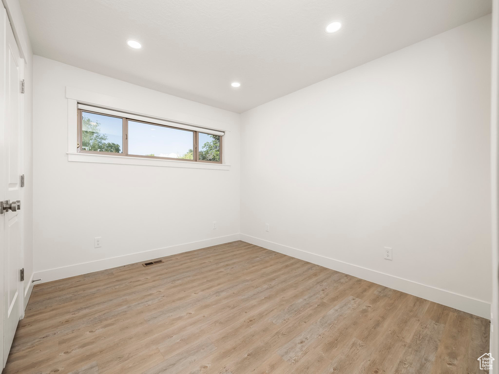 Unfurnished room featuring baseboards, light wood-style floors, and recessed lighting