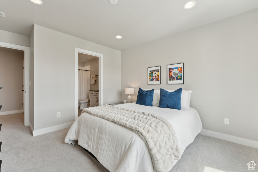 Bedroom featuring light colored carpet, recessed lighting, baseboards, and ensuite bathroom