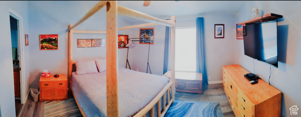 Bedroom with wood finished floors and baseboards
