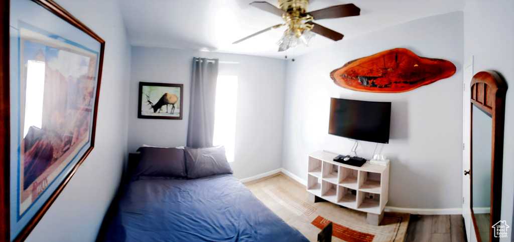 Bedroom with wood finished floors, baseboards, and a ceiling fan