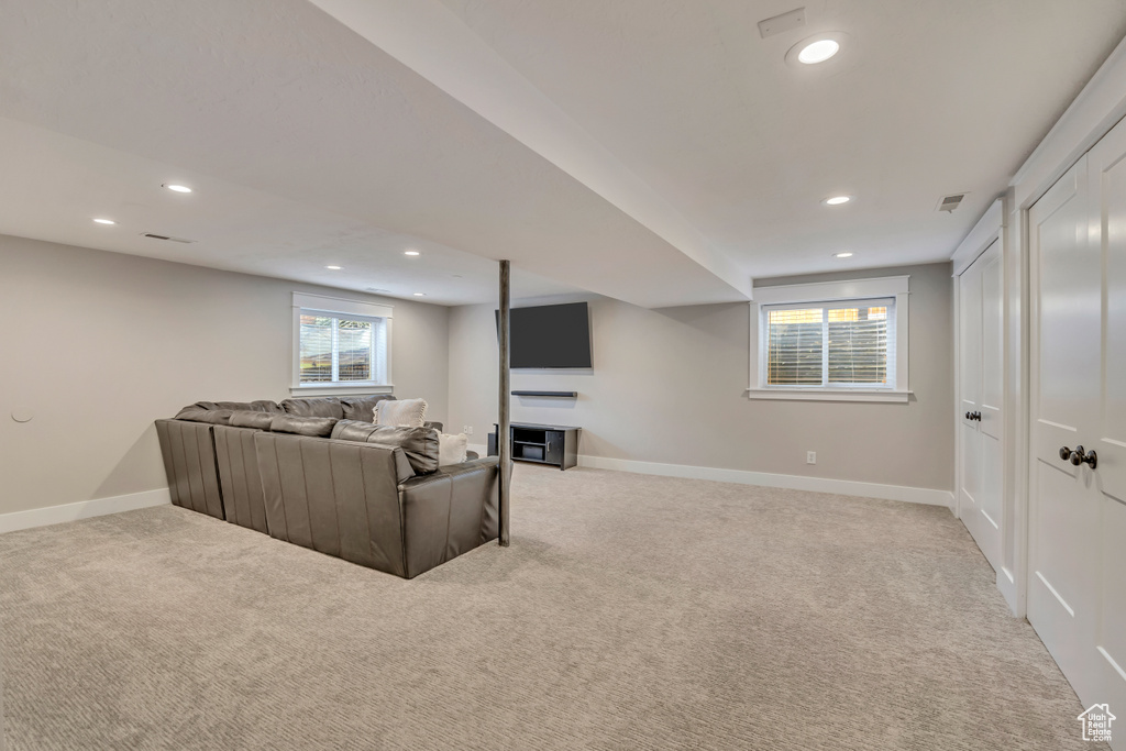 Living room with light carpet, recessed lighting, and baseboards