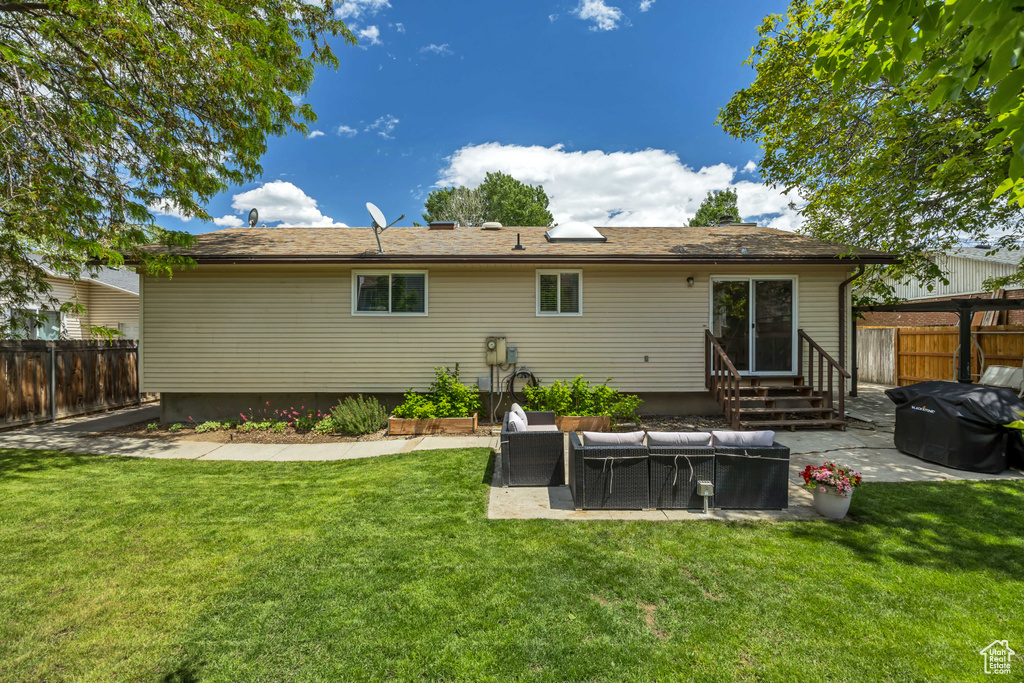 Rear view of property with entry steps, an outdoor hangout area, and a patio area