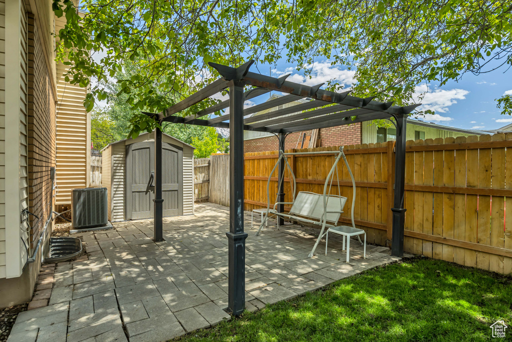 Fenced backyard with central air condition unit, a pergola, and a patio