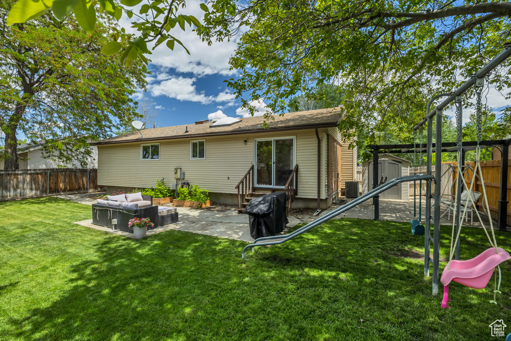Rear view of house with a patio, entry steps, central AC unit, and outdoor lounge area