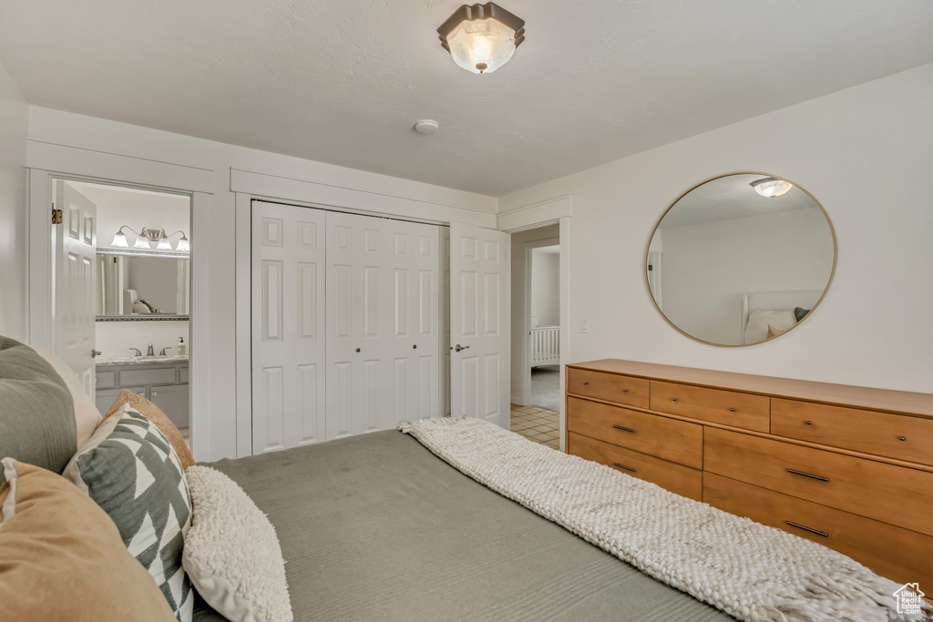 Bedroom featuring ensuite bath, a closet, and carpet flooring