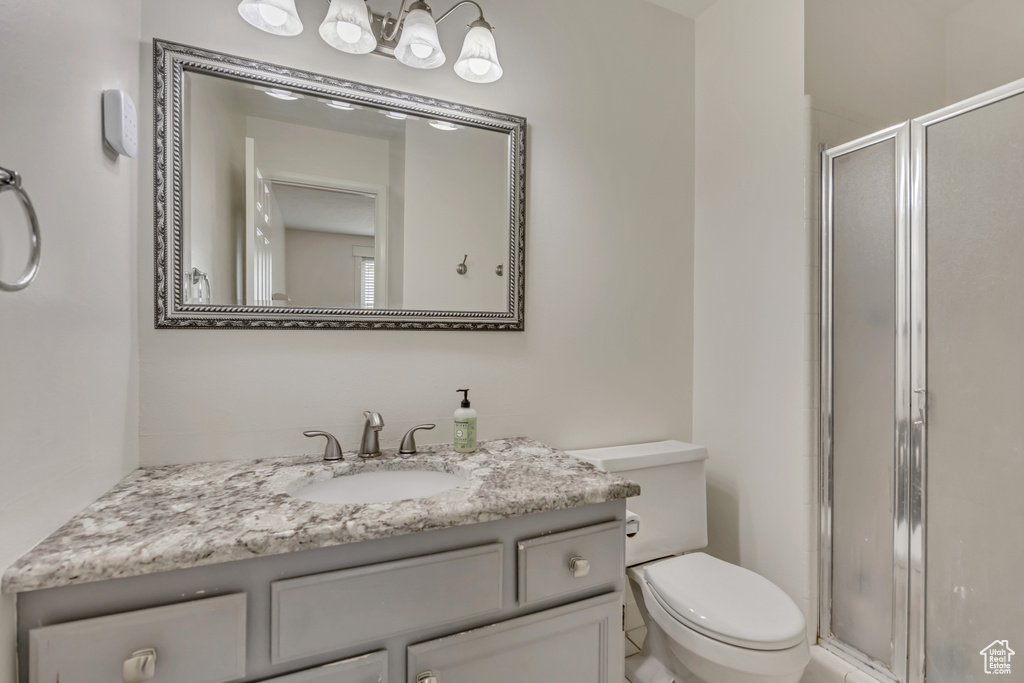 Full bathroom with a stall shower, toilet, and vanity