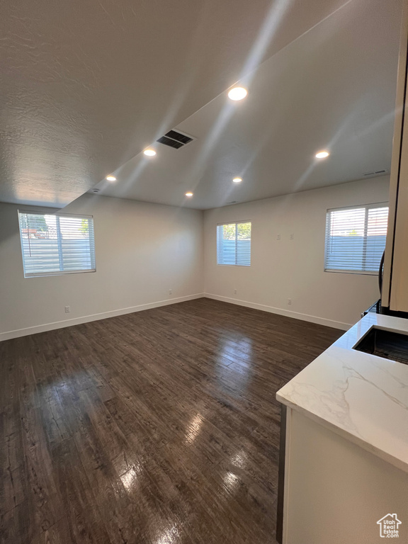 Unfurnished room featuring dark wood-type flooring, baseboards, and recessed lighting
