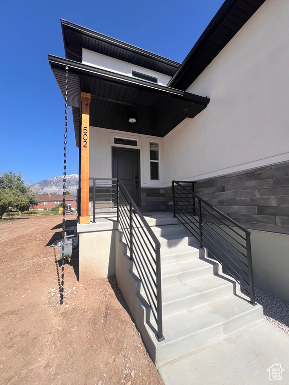 Property entrance with a mountain view, stucco siding, and covered porch