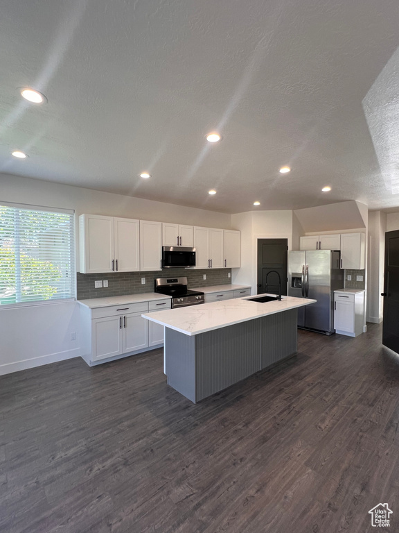 Kitchen featuring stainless steel appliances, a sink, dark wood-style flooring, white cabinets, and recessed lighting
