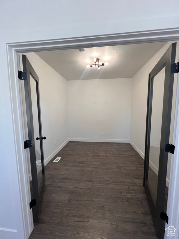 Unfurnished room featuring dark wood-style floors and baseboards