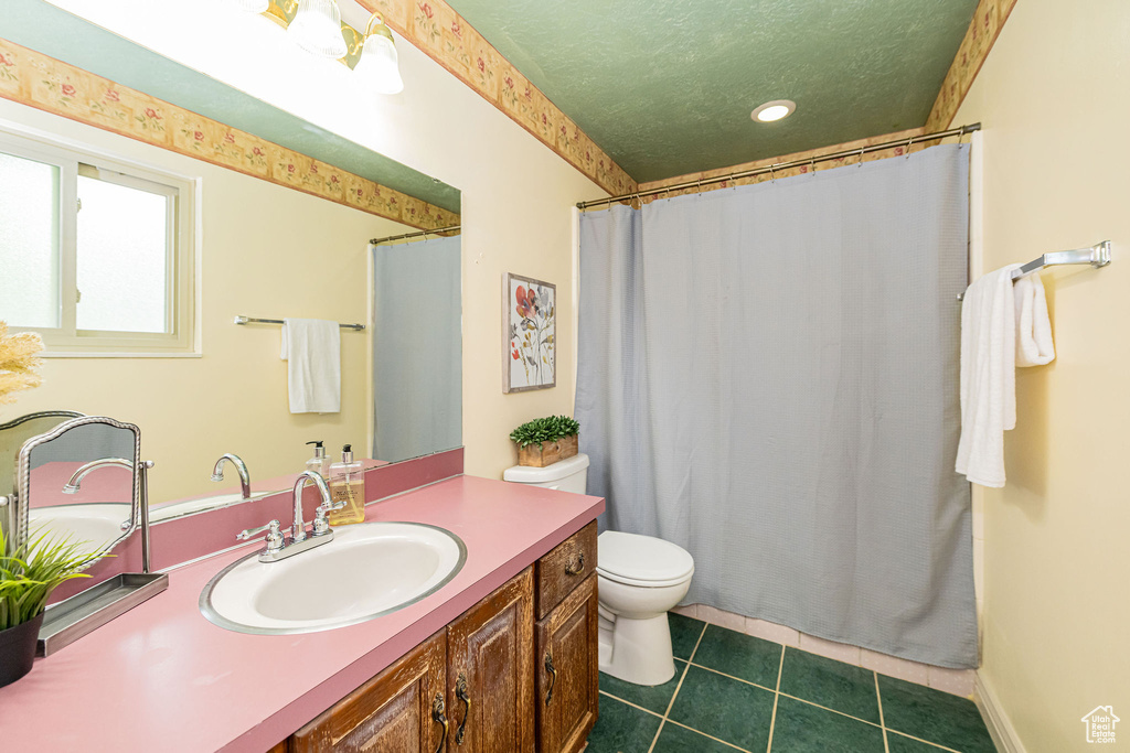 Bathroom featuring toilet, tile patterned floors, vanity, recessed lighting, and a textured ceiling