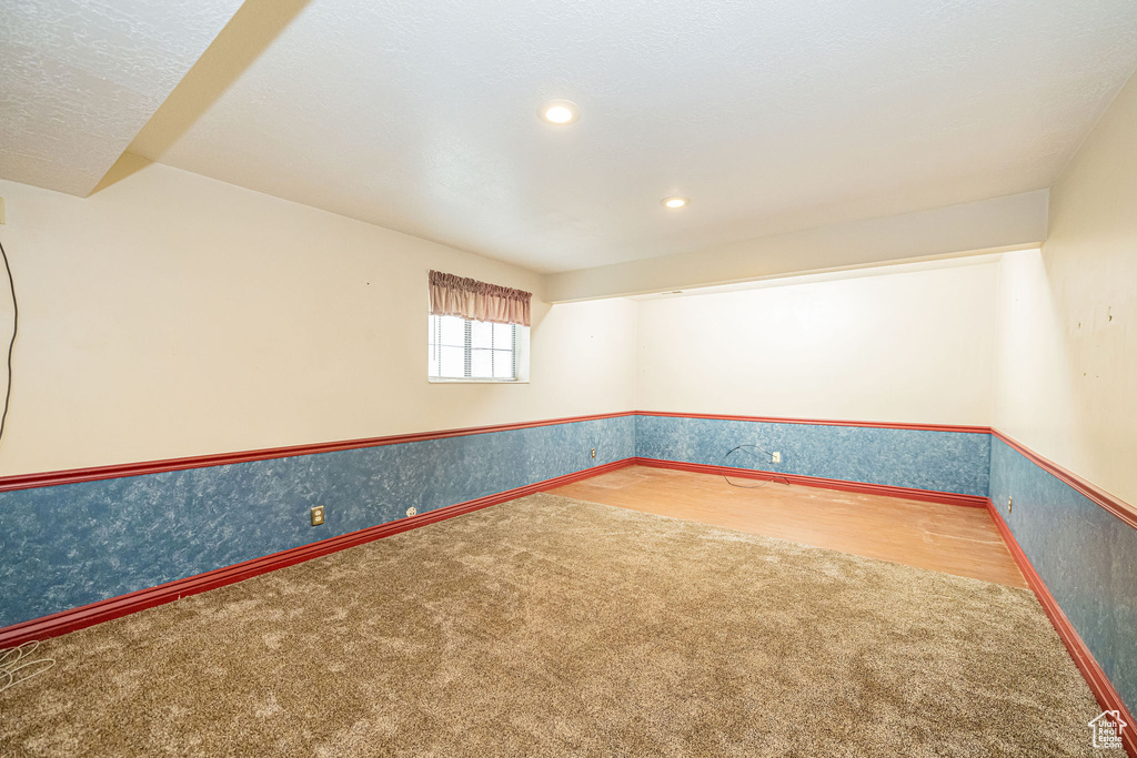 Carpeted spare room featuring wallpapered walls, recessed lighting, and a wainscoted wall
