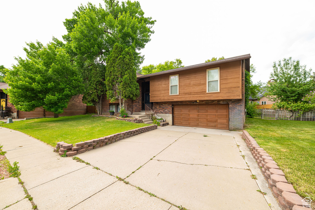 View of front of property with an attached garage and concrete driveway