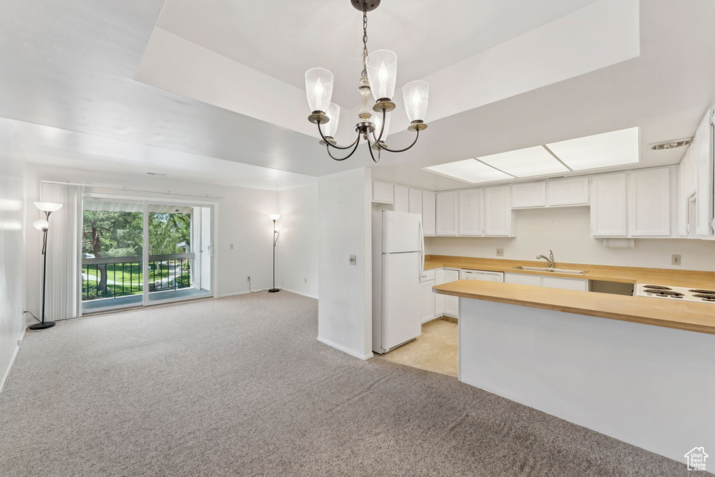 Kitchen with freestanding refrigerator, a sink, light colored carpet, open floor plan, and butcher block counters