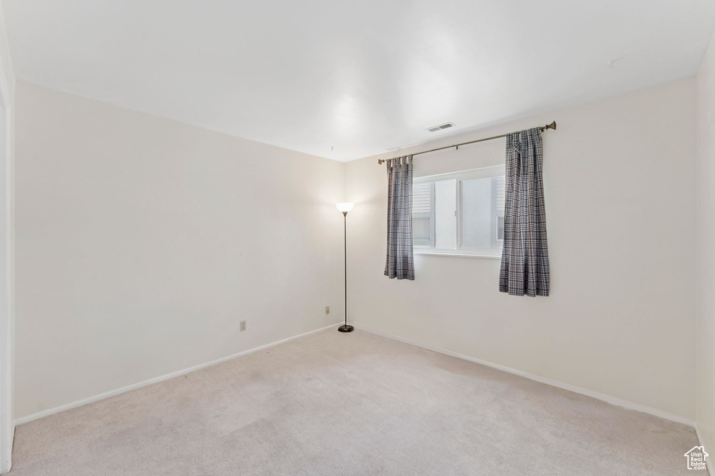 Spare room featuring carpet and baseboards