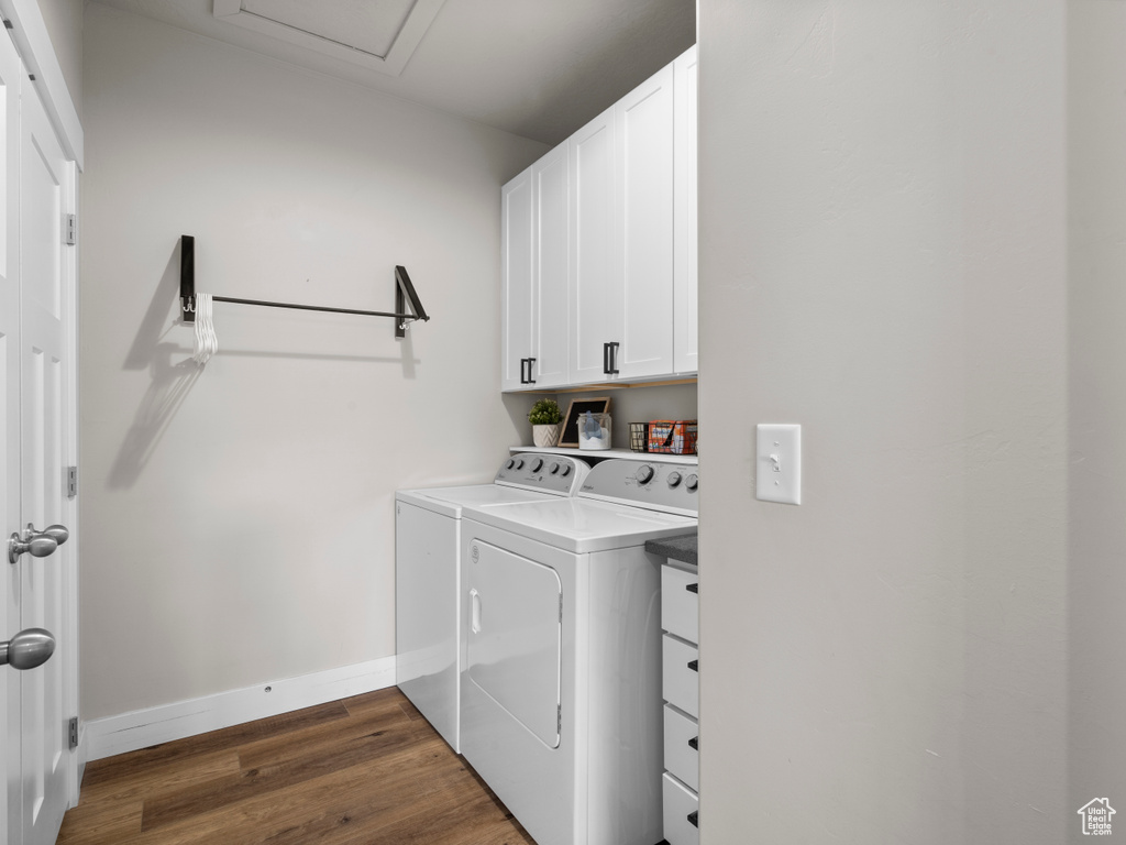 Laundry room with independent washer and dryer, cabinet space, baseboards, and dark wood finished floors
