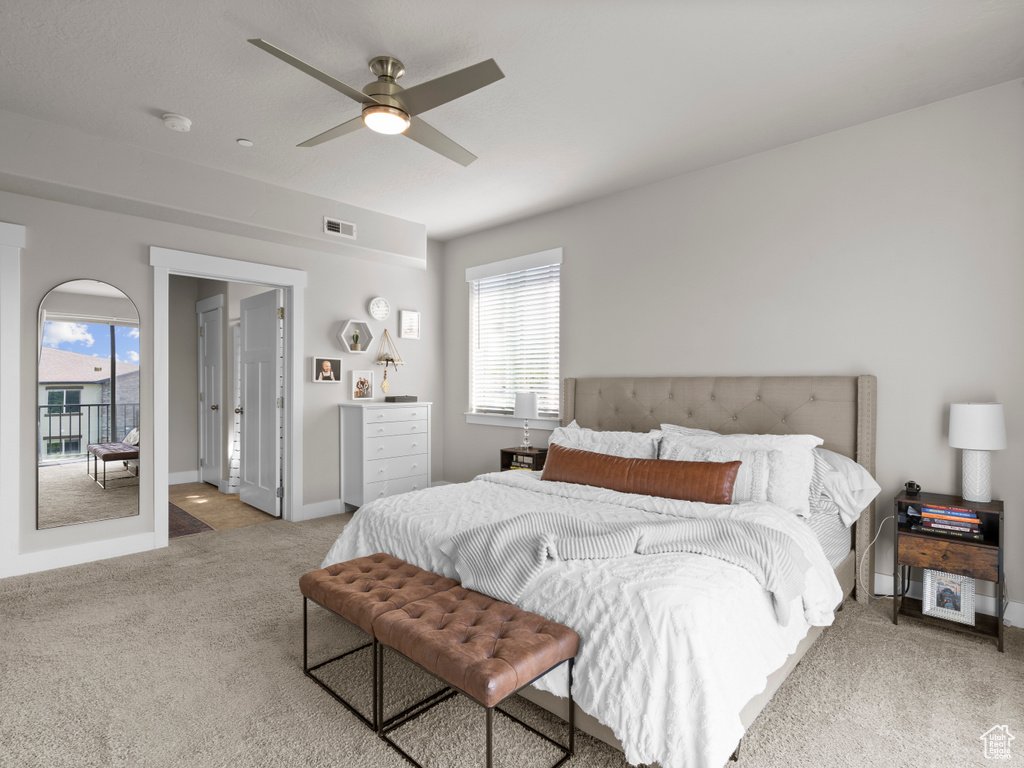 Carpeted bedroom with multiple windows, a ceiling fan, and baseboards