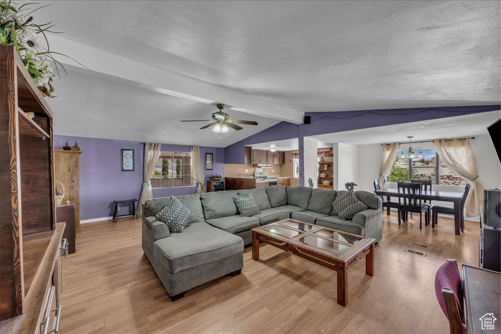 Living area with light wood-style flooring, plenty of natural light, and a ceiling fan