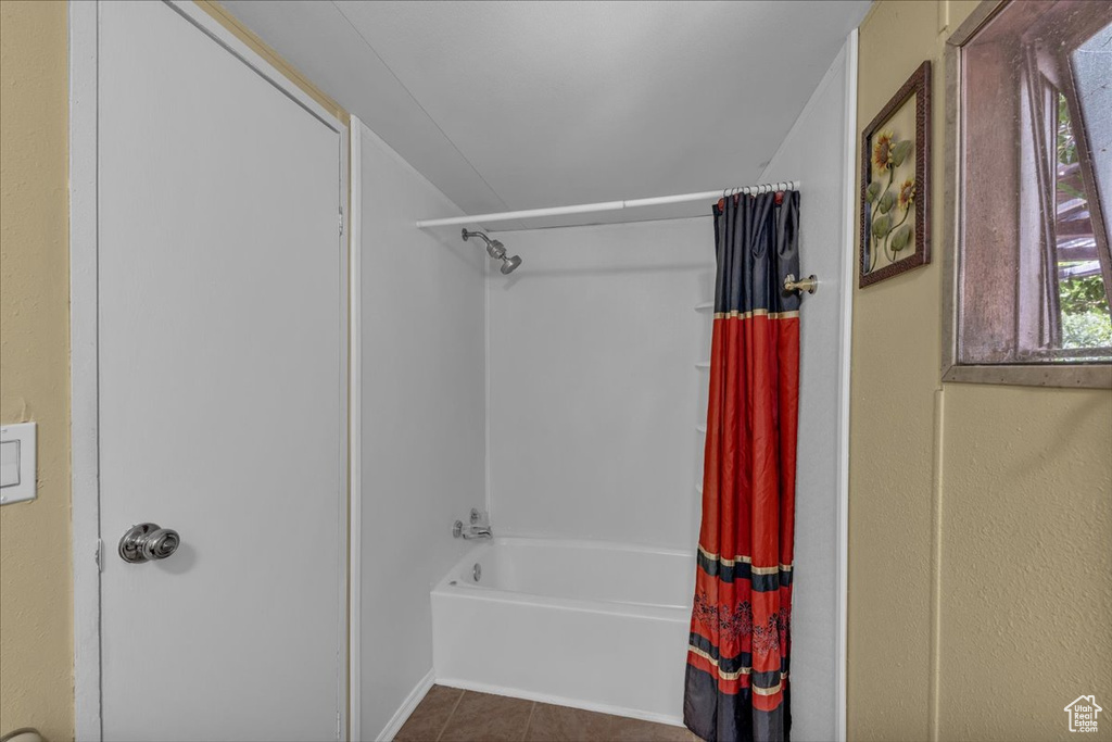 Full bath featuring shower / bathtub combination with curtain and tile patterned flooring