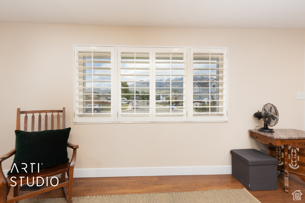 Living area featuring baseboards, wood finished floors, and plenty of natural light