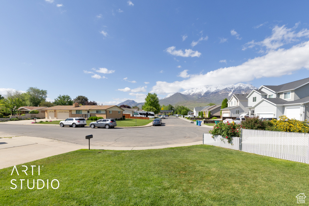 View of green lawn featuring a residential view and a mountain view