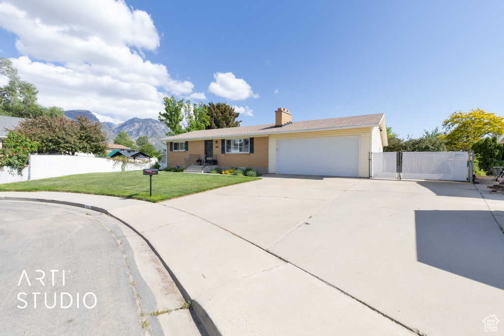Single story home with driveway, a chimney, a gate, a garage, and a mountain view