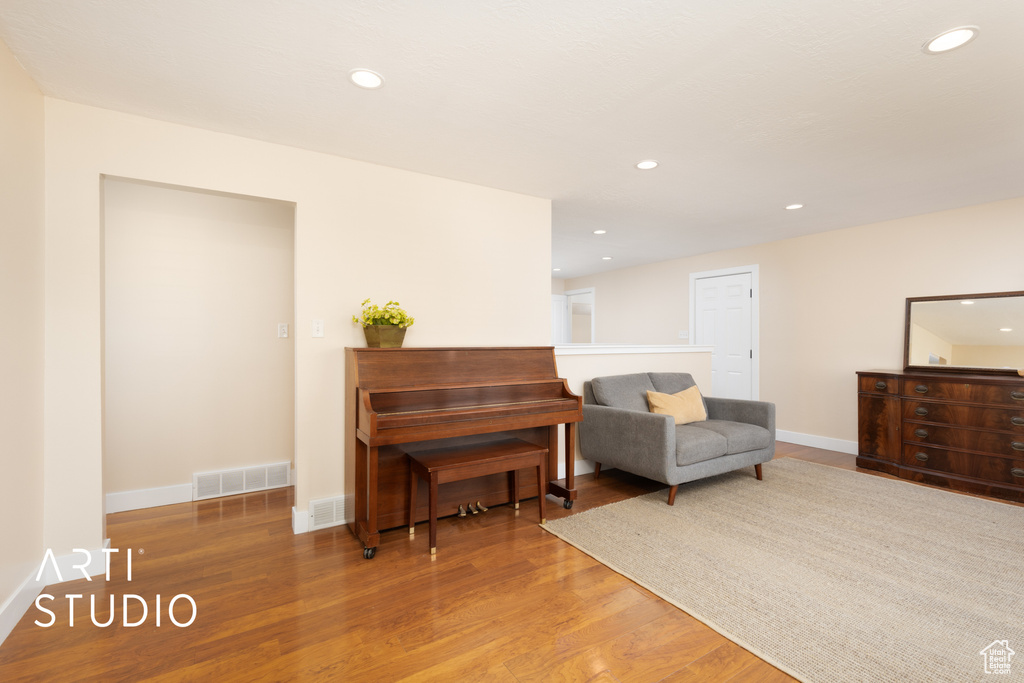 Living area with wood finished floors, recessed lighting, and baseboards