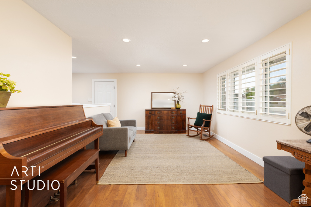 Living area with wood finished floors, baseboards, and recessed lighting