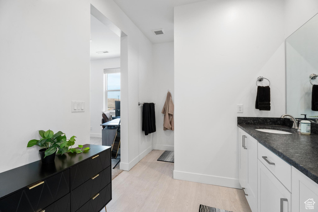 Bathroom with wood finished floors, baseboards, and vanity