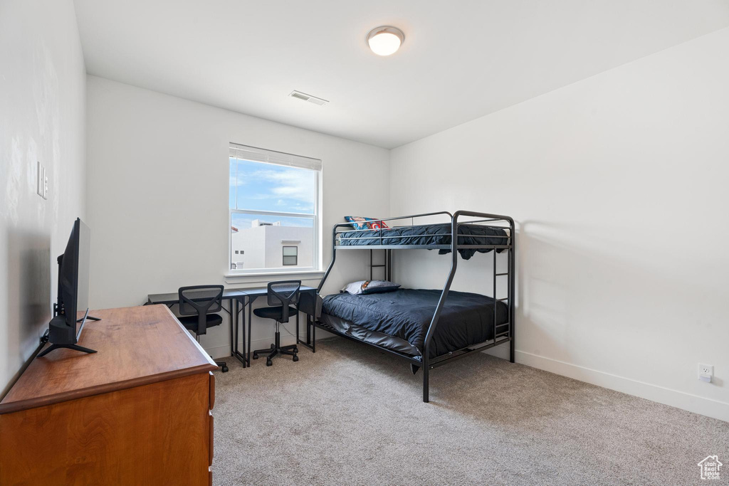 Bedroom featuring carpet, baseboards, and a desk