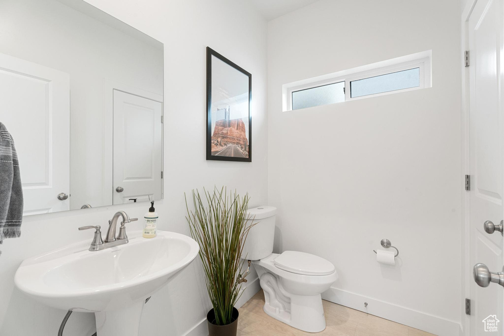 Half bath featuring toilet, a sink, and baseboards
