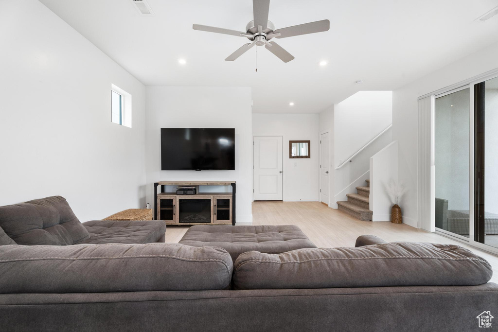 Living area featuring stairway, light wood-style flooring, a ceiling fan, recessed lighting, and baseboards