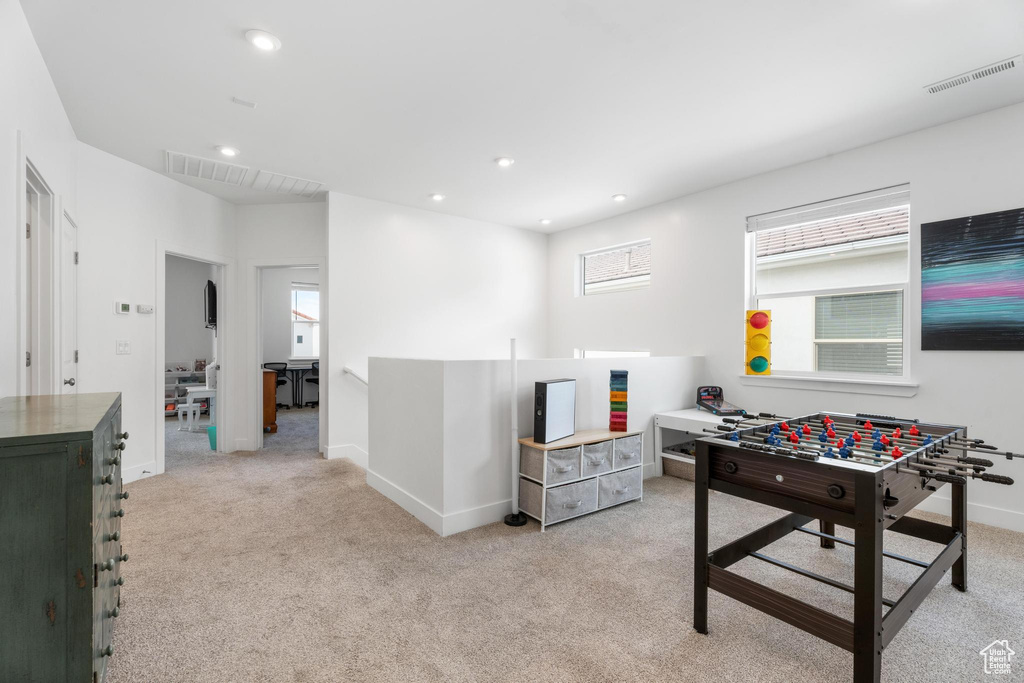 Recreation room featuring light carpet, baseboards, and recessed lighting