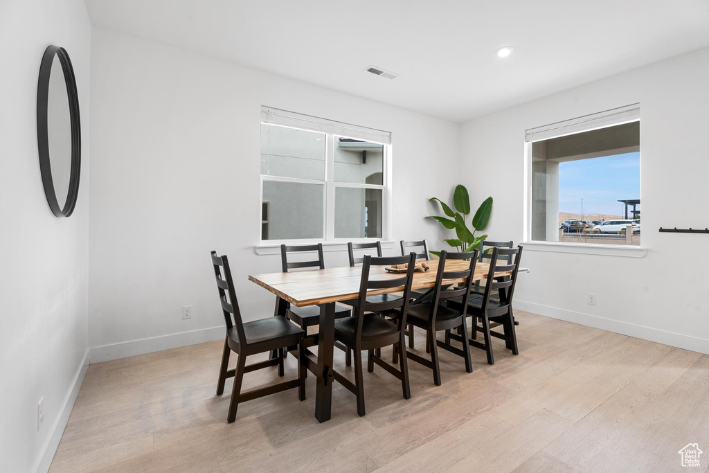 Dining area with light wood finished floors, baseboards, and recessed lighting