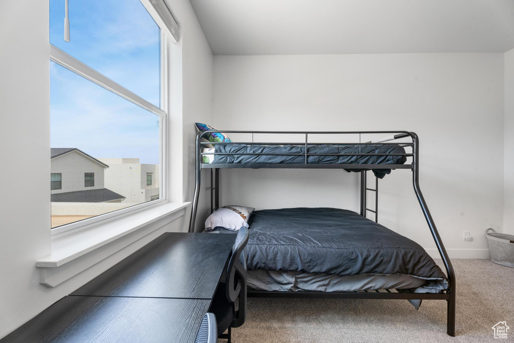 Bedroom featuring carpet and baseboards