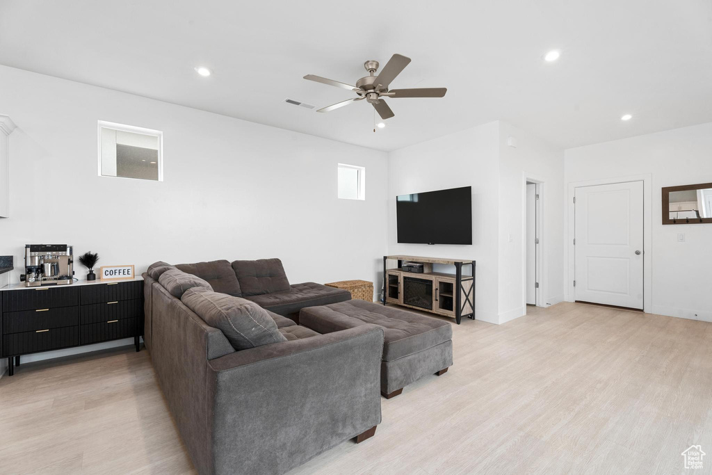 Living room featuring light wood-style flooring, ceiling fan, and recessed lighting