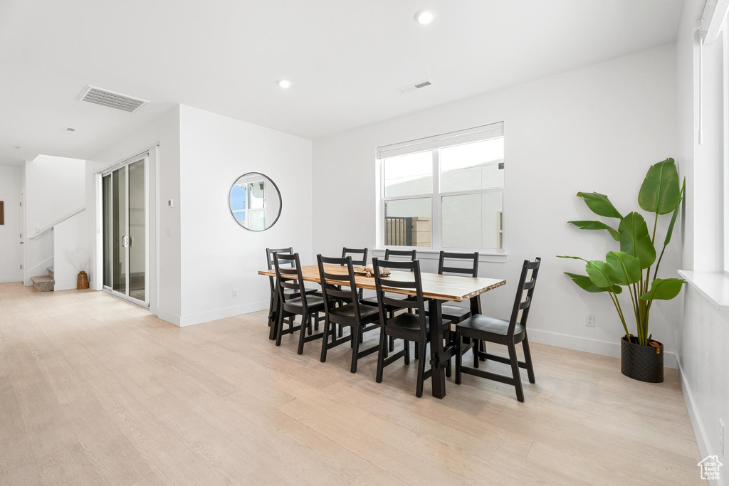 Dining space featuring light wood-style floors, baseboards, recessed lighting, and stairway