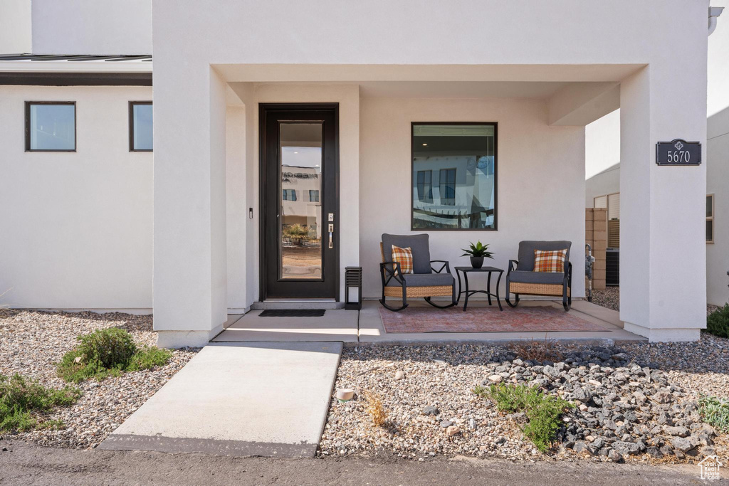 Doorway to property with stucco siding and covered porch