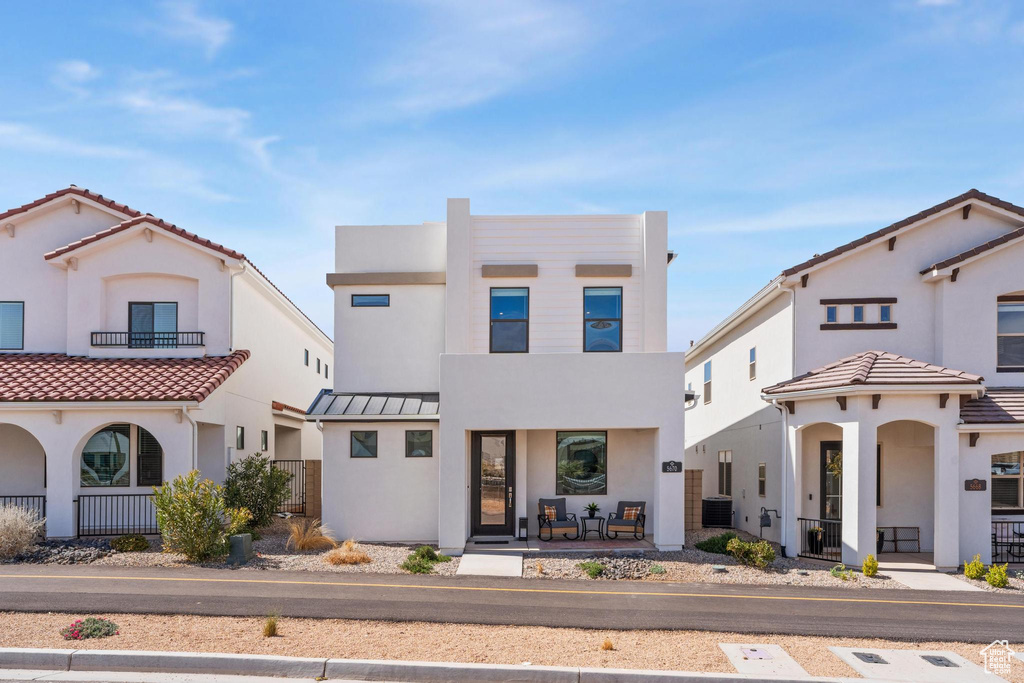 View of front of home featuring stucco siding, covered porch, and central AC unit
